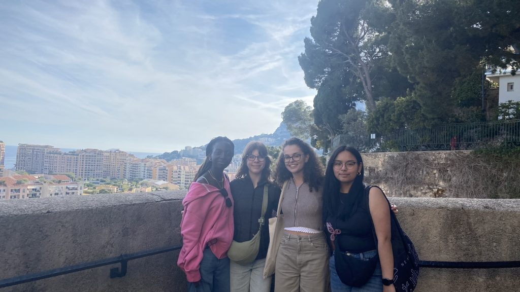 From left to right, Teni, Scarlett, Grace, and Angelina standing in front of a panoramic view in Monaco